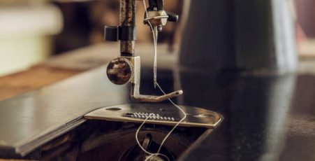 Close-up image of the needle of a vintage sewing machine.